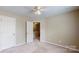 Neutral bedroom featuring soft carpet, a ceiling fan, and closet at 12222 Stratfield Place Cir, Pineville, NC 28134