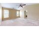 Spacious bedroom featuring neutral walls, carpet, a ceiling fan, and natural light from two windows at 12222 Stratfield Place Cir, Pineville, NC 28134