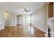 Bright living room featuring hardwood floors, a ceiling fan, and a view of the front door at 12222 Stratfield Place Cir, Pineville, NC 28134