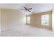 Spacious main bedroom featuring soft carpet, two windows, and a ceiling fan at 12222 Stratfield Place Cir, Pineville, NC 28134