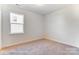 Carpeted bedroom bathed in natural light from a large window, enhancing the inviting space at 123 Prestwick Way # 42, Mooresville, NC 28115