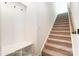 Hallway has carpeted stairs with a coat rack and seat, perfect for a welcoming entrance at 123 Prestwick Way # 42, Mooresville, NC 28115