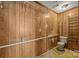 Bathroom with wood paneling and a toilet with safety railing at 1333 Washington Ln, Kannapolis, NC 28083