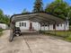 Exterior of a light gray home with a carport, green lawn, and a concrete driveway at 1333 Washington Ln, Kannapolis, NC 28083