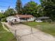 Exterior view of a home with a carport and fenced yard under a canopy of trees at 1333 Washington Ln, Kannapolis, NC 28083