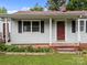 A tidy single-story home has a quaint porch entry with a neat garden bed lining the foundation at 1333 Washington Ln, Kannapolis, NC 28083