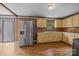 Kitchen features stainless steel refrigerator, ample cabinetry, and wood flooring for functionality and style at 1333 Washington Ln, Kannapolis, NC 28083