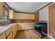 Kitchen featuring wood paneling, light yellow cabinets, and an updated stove at 1333 Washington Ln, Kannapolis, NC 28083
