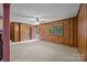 The carpeted living room offers wood paneling, a ceiling fan, and backyard access for indoor-outdoor living at 1333 Washington Ln, Kannapolis, NC 28083