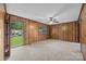 This cozy living room has wood paneling, a ceiling fan, and a sliding door for natural light at 1333 Washington Ln, Kannapolis, NC 28083