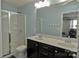 Well-lit bathroom boasts a double sink vanity, white shower, and complementing blue walls and floor mat at 137 Flora Vista Dr, Mooresville, NC 28117