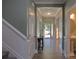 Hallway with hardwood floors, leading to various rooms, including a powder room, and a view of the front door at 137 Flora Vista Dr, Mooresville, NC 28117
