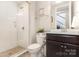 Bright bathroom with glass enclosed shower and a vanity with dark wood cabinets at 14228 Twin Eagles Ln, Charlotte, NC 28278