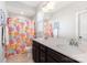Bright bathroom featuring a double vanity, mirror, and floral shower curtain at 14228 Twin Eagles Ln, Charlotte, NC 28278