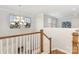 Foyer with chandelier lighting and railing with wood trim at 14228 Twin Eagles Ln, Charlotte, NC 28278