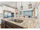 Kitchen island with granite countertop, stainless steel sink, and modern pendant lighting at 14228 Twin Eagles Ln, Charlotte, NC 28278