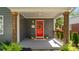 Inviting front porch with a vibrant red door, seasonal wreath, and decorative plants for a warm welcome at 1446 Downs Ave, Charlotte, NC 28205