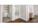 Hallway view to a bathroom and laundry space, featuring hardwood floors and white trim at 1446 Downs Ave, Charlotte, NC 28205