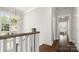 Upstairs hallway features wood floors, a decorative light fixture, and leads to the home's bedrooms at 1446 Downs Ave, Charlotte, NC 28205