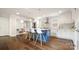 Stylish kitchen featuring a blue island with seating, white cabinets, and stainless steel appliances at 1446 Downs Ave, Charlotte, NC 28205