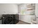 Modern laundry room with front loading washer and dryer, white cabinets and plenty of storage at 1446 Downs Ave, Charlotte, NC 28205