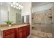 Bathroom with a glass-enclosed shower, wood vanity, and granite countertops at 1500 Tarrington Way, Wesley Chapel, NC 28079