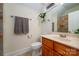 Bathroom featuring a tiled shower, vanity with sink, a mirror, and a toilet with a window in the background at 1500 Tarrington Way, Wesley Chapel, NC 28079
