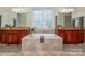 Luxurious bathroom featuring a soaking tub, double vanities, and natural stone tile at 1500 Tarrington Way, Wesley Chapel, NC 28079