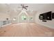 Spacious bonus room featuring hardwood floors, multiple windows, a ceiling fan, and built-in shelves at 1500 Tarrington Way, Wesley Chapel, NC 28079