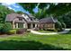 Beautiful brick home featuring lush landscaping, inviting walkway, and mature trees at 1500 Tarrington Way, Wesley Chapel, NC 28079
