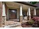 Inviting covered porch with stone columns, brick accents, and a stylish front door at 1500 Tarrington Way, Wesley Chapel, NC 28079