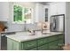 Close up of the kitchen island featuring marble countertops, a sink, and custom green cabinetry at 1500 Tarrington Way, Wesley Chapel, NC 28079