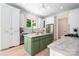 Bright kitchen showcasing a green island, stainless steel appliances, and white cabinetry at 1500 Tarrington Way, Wesley Chapel, NC 28079