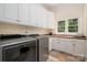 Laundry room equipped with modern appliances, storage cabinets, and a window at 1500 Tarrington Way, Wesley Chapel, NC 28079