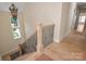 Bright foyer showcasing a wooden staircase with decorative iron railings and natural light from a nearby window at 1500 Tarrington Way, Wesley Chapel, NC 28079