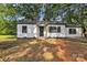Charming white home with black trim, a cozy front porch and a large lot with mature shade trees at 1739 16Th Ne St, Hickory, NC 28601