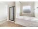 Clean bathroom featuring a shower, tub, and a bright window to allow natural light to enter the space at 178 Wellshire St, Mooresville, NC 28115