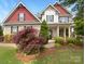 Charming two-story home featuring a well-manicured lawn, lush landscaping, and inviting entrance at 178 Wellshire St, Mooresville, NC 28115