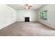 Bright living room featuring a fireplace, plush carpeting, and a large window overlooking the yard at 178 Wellshire St, Mooresville, NC 28115