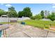 Spacious backyard with mature trees, green grass, white picket fence, swing, and concrete patio at 1911 Savannah Hills Dr, Matthews, NC 28105