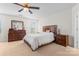 Bright bedroom featuring a ceiling fan, matching wood furniture set, and neutral carpet at 1911 Savannah Hills Dr, Matthews, NC 28105