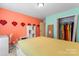 Bright bedroom with colorful walls, built-in shelving, closet, and a yellow comforter at 1911 Savannah Hills Dr, Matthews, NC 28105