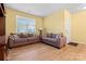 Bright living room with wood-look flooring, featuring two plush sofas and a large window for ample natural light at 1911 Savannah Hills Dr, Matthews, NC 28105