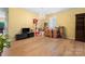Spacious living area with modern wood-look floors, a chandelier, a black TV console, and window views at 1911 Savannah Hills Dr, Matthews, NC 28105