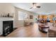 Spacious living room flowing into kitchen, featuring fireplace, ceiling fan, and wood flooring at 1911 Savannah Hills Dr, Matthews, NC 28105