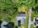 Aerial view showcasing a home with a well-maintained lawn, mature trees, and surrounding greenery at 2011 20Th Street Ne Pl, Hickory, NC 28601