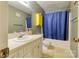 Well-lit bathroom featuring a vanity with sink, toilet, and shower with blue curtain at 2011 20Th Street Ne Pl, Hickory, NC 28601