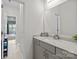 Bright bathroom featuring a sink, mirror, with a peek to an adjacent bedroom at 20307 Creek Bend Edge Ct # 10, Matthews, NC 28105