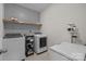 Practical laundry room with modern appliances, patterned wallpaper, and storage shelf at 20307 Creek Bend Edge Ct # 10, Matthews, NC 28105