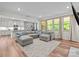 Bright, open living room featuring a gray sectional sofa, wood floors and large windows at 20307 Creek Bend Edge Ct # 10, Matthews, NC 28105
